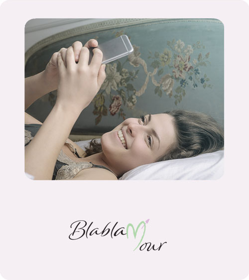 Image montrant une jeune femme en train d'envoyer un SMS romantique dans son lit.